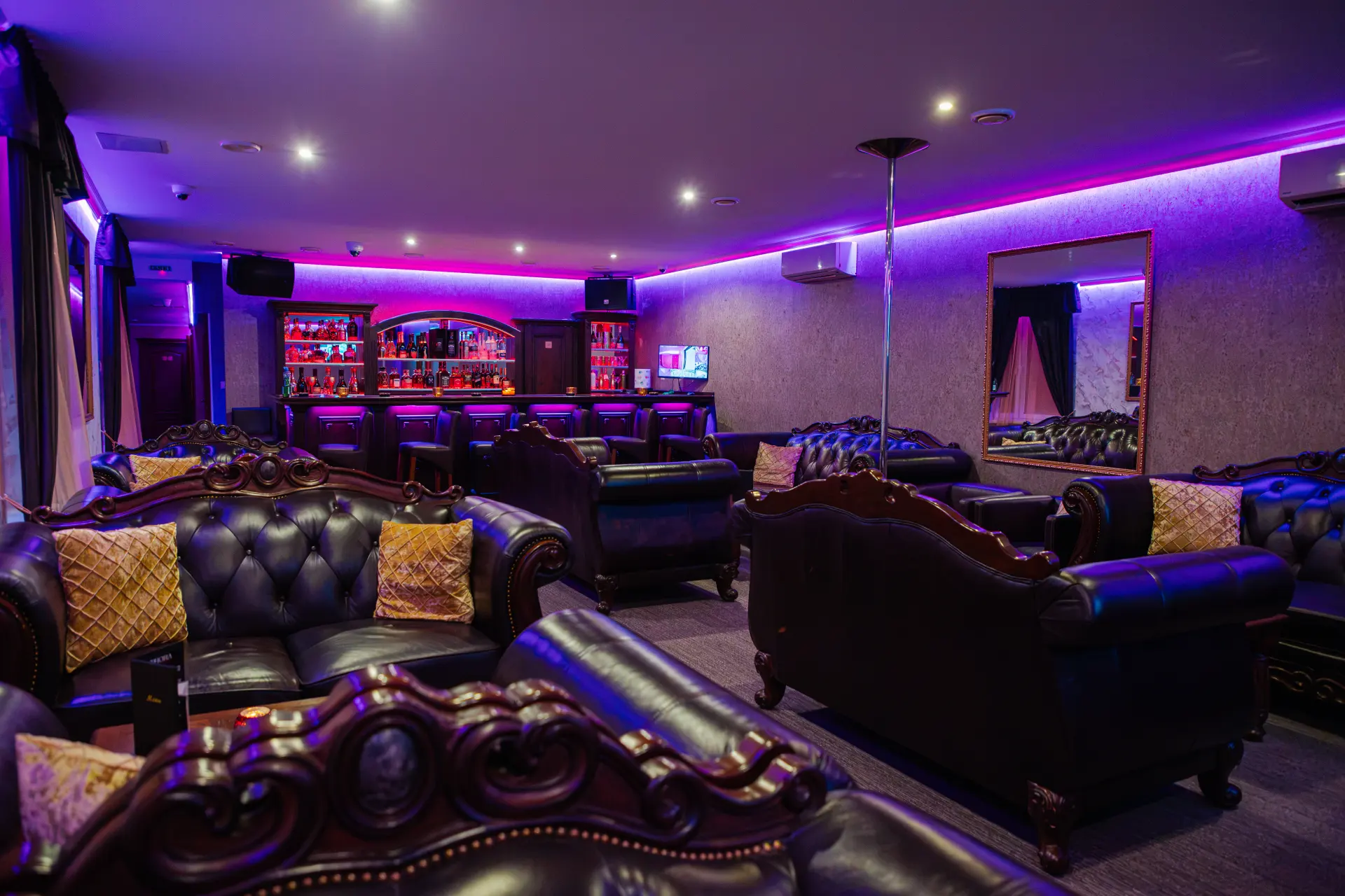 Kožené sedačky v lounge s barom a zrkadlom v pozadí